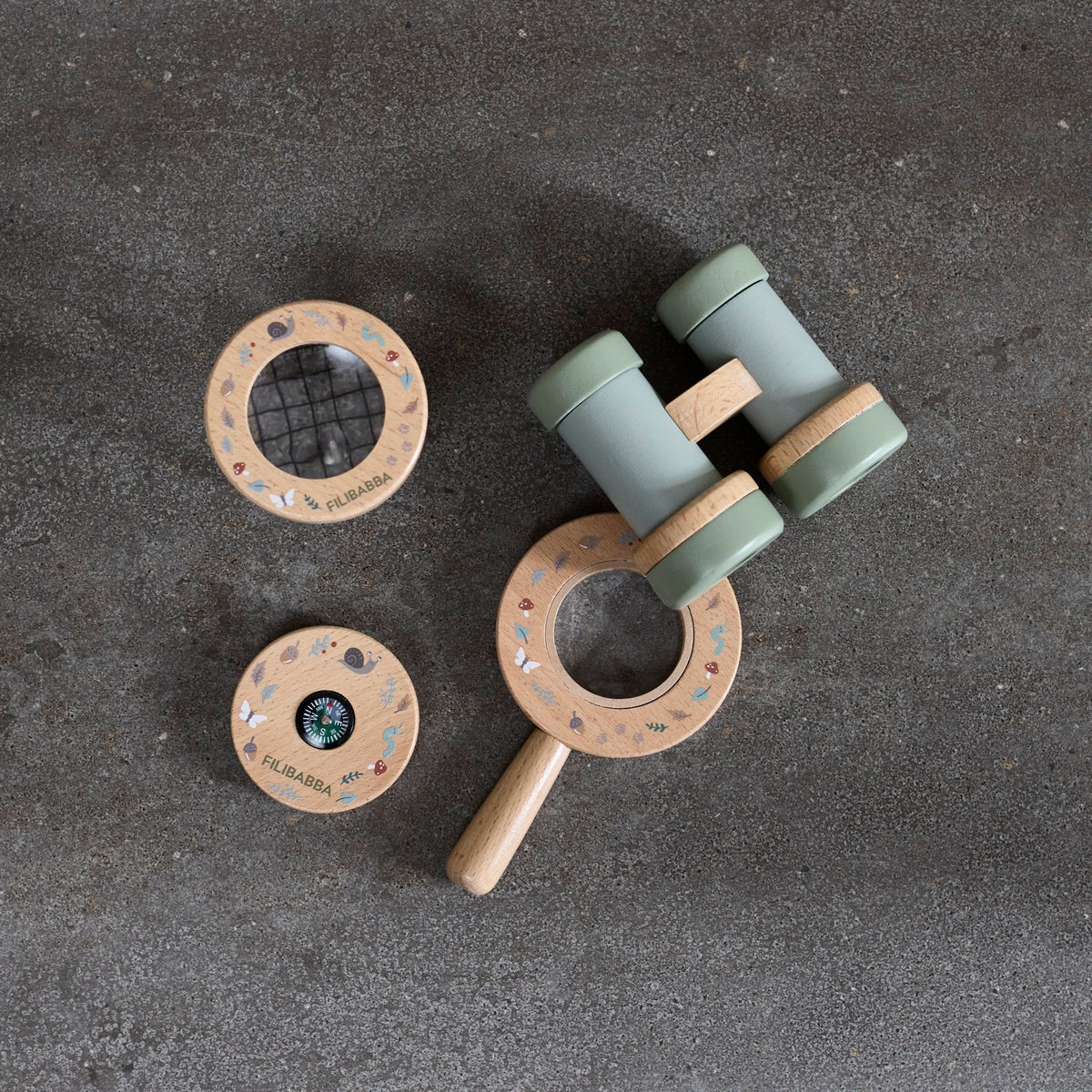 Wooden baby rattle with green accents on a dark surface