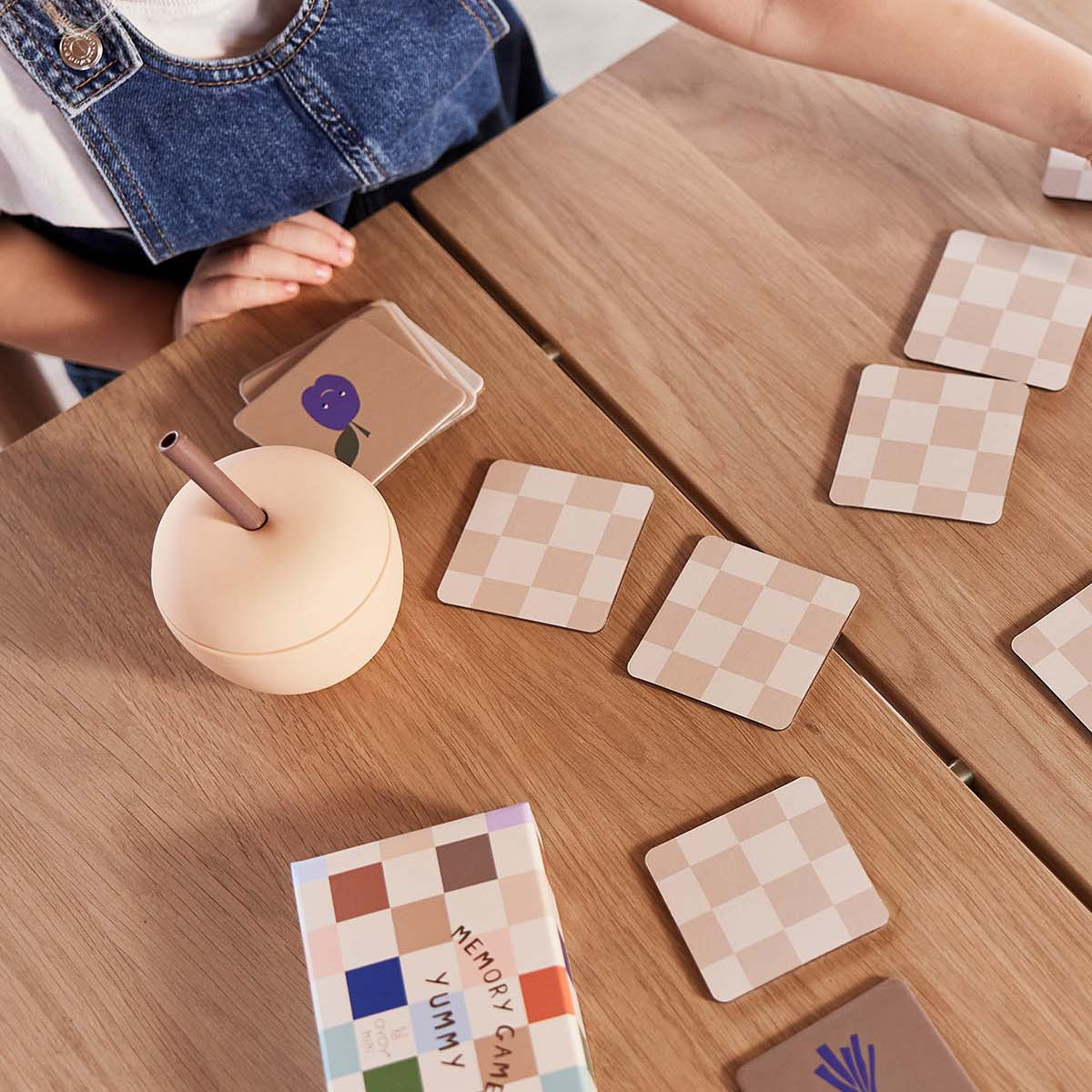 Wooden table with checkered coasters and a colorful memory card