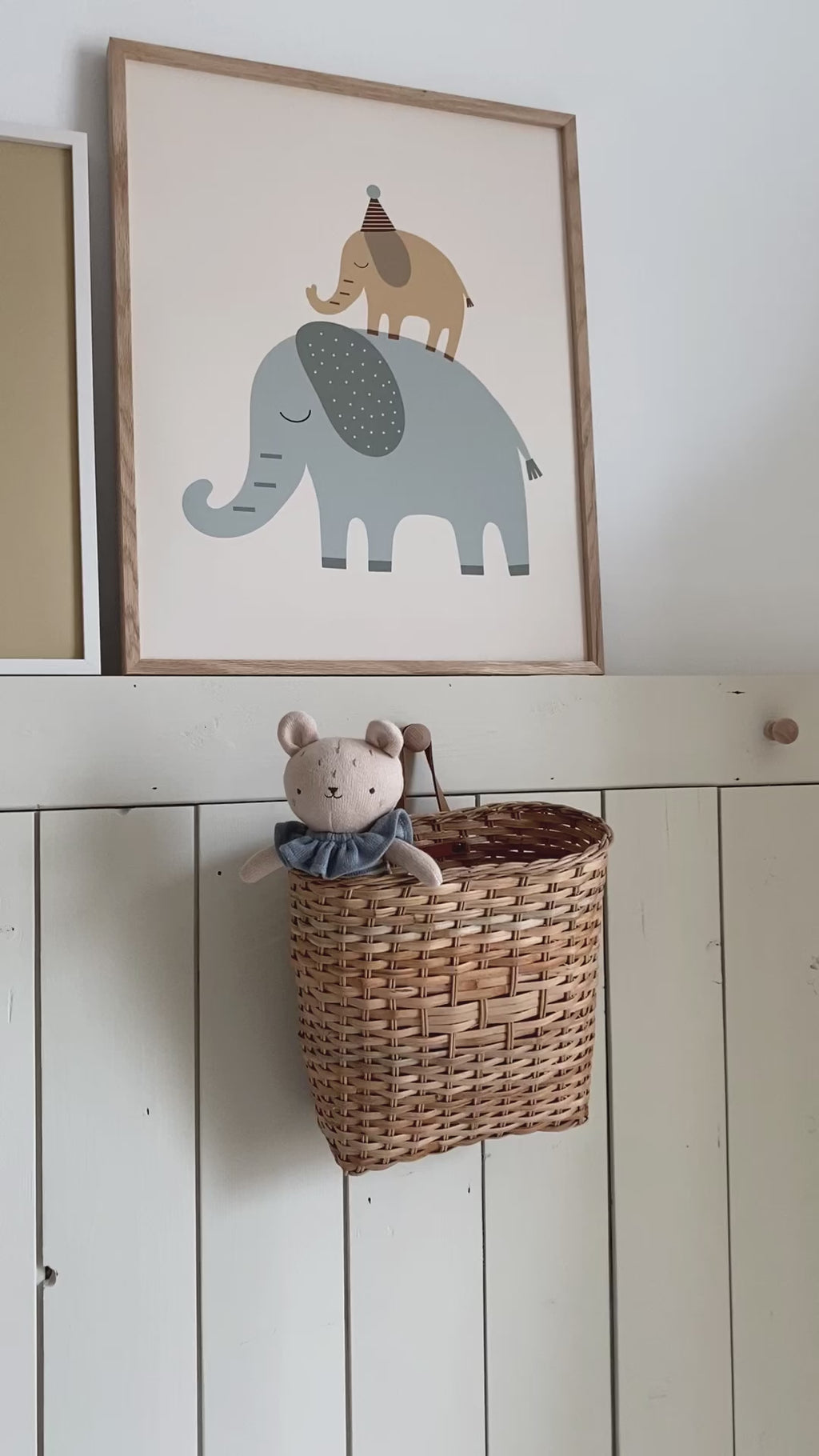 Knitted Bear toy in basket with Elephant poster in background